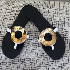 Giuseppe Zanotti white slides with gold trim.